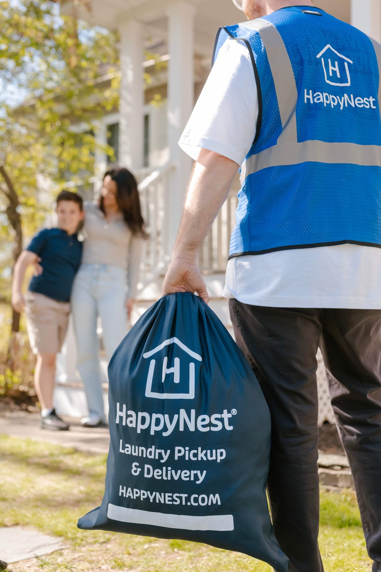 HappyNest delivery driver holding bag and delivering to family who needs their clothes washed, dried, folded, and delivered next-day.