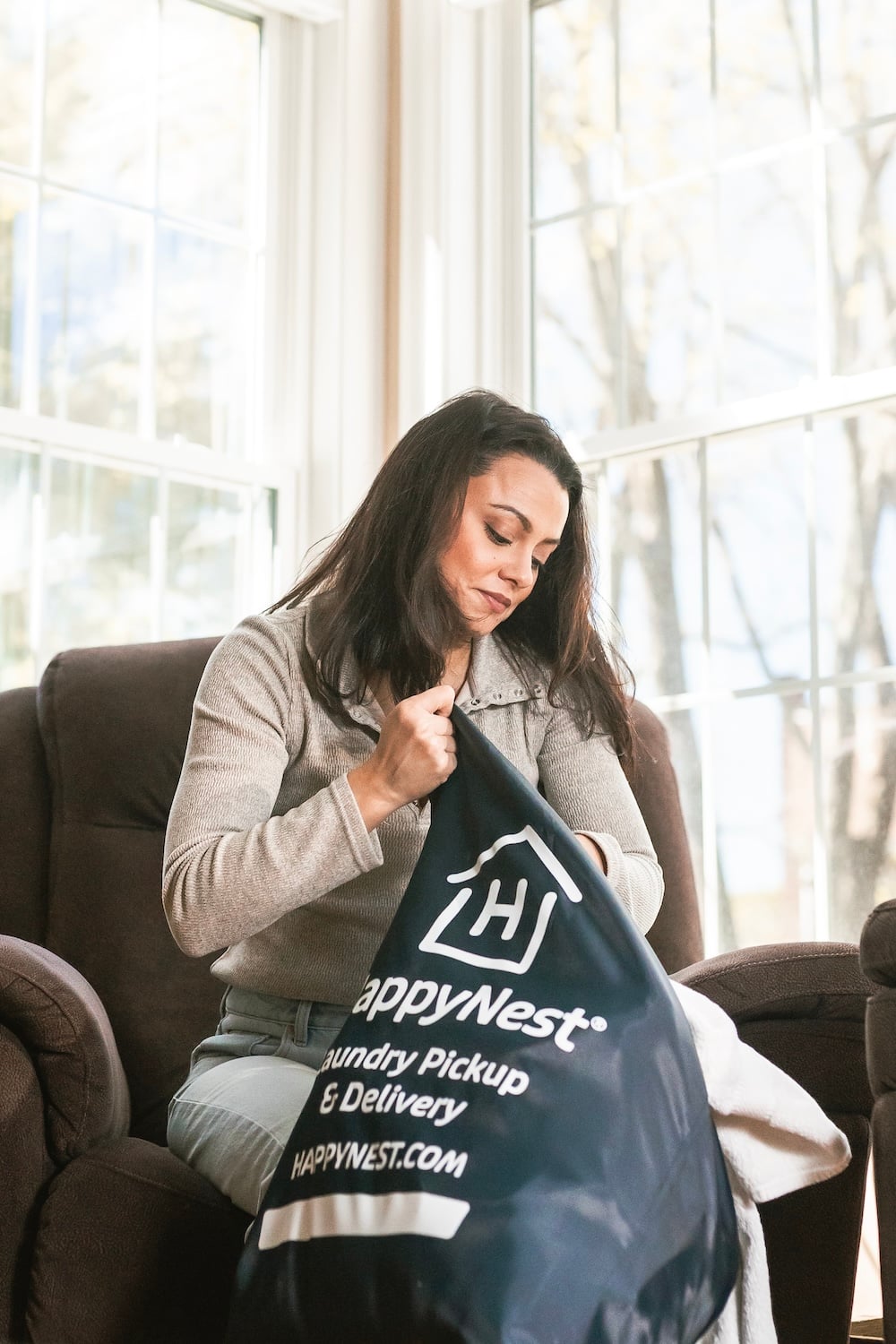 Woman filling HappyNest laundry bag for pickup